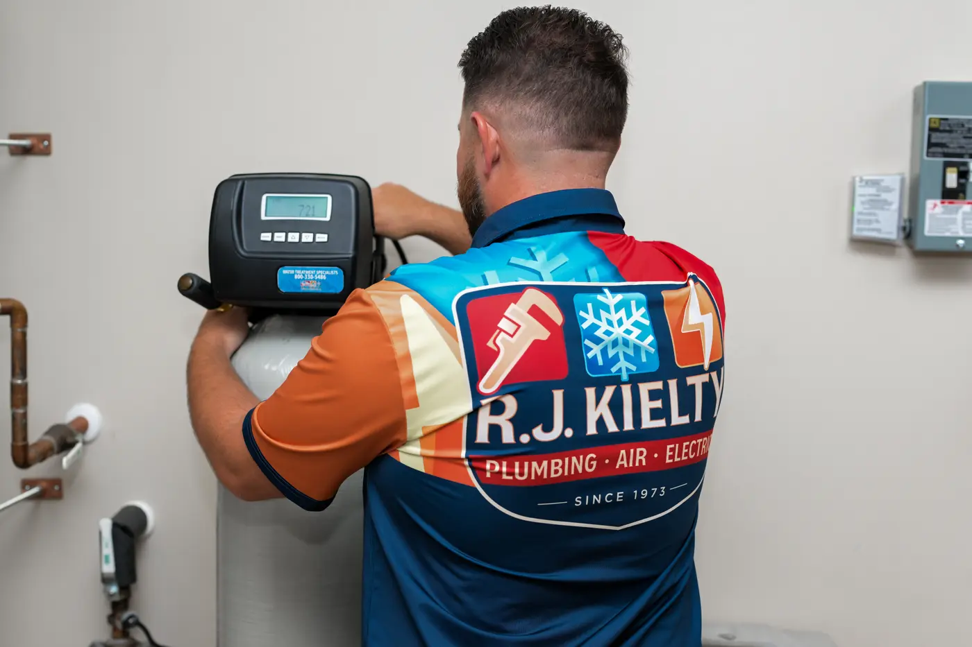 A technician setting the control valve on a whole-home water softener